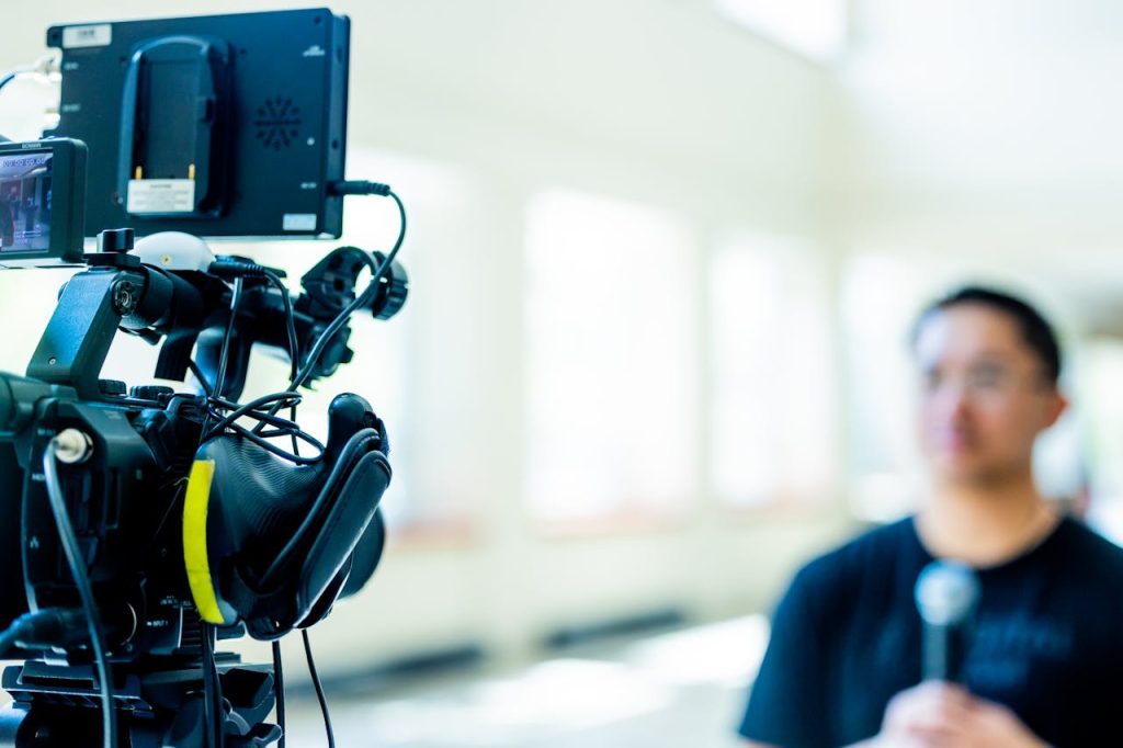 Professional video camera setup focusing on an interview with blurred subject in the background.
